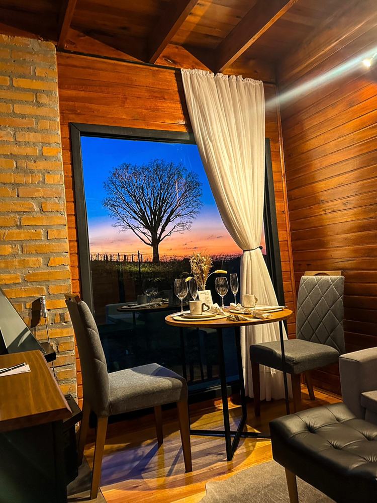 Mesa posta na Cabana Premium com o pôr do sol na janela