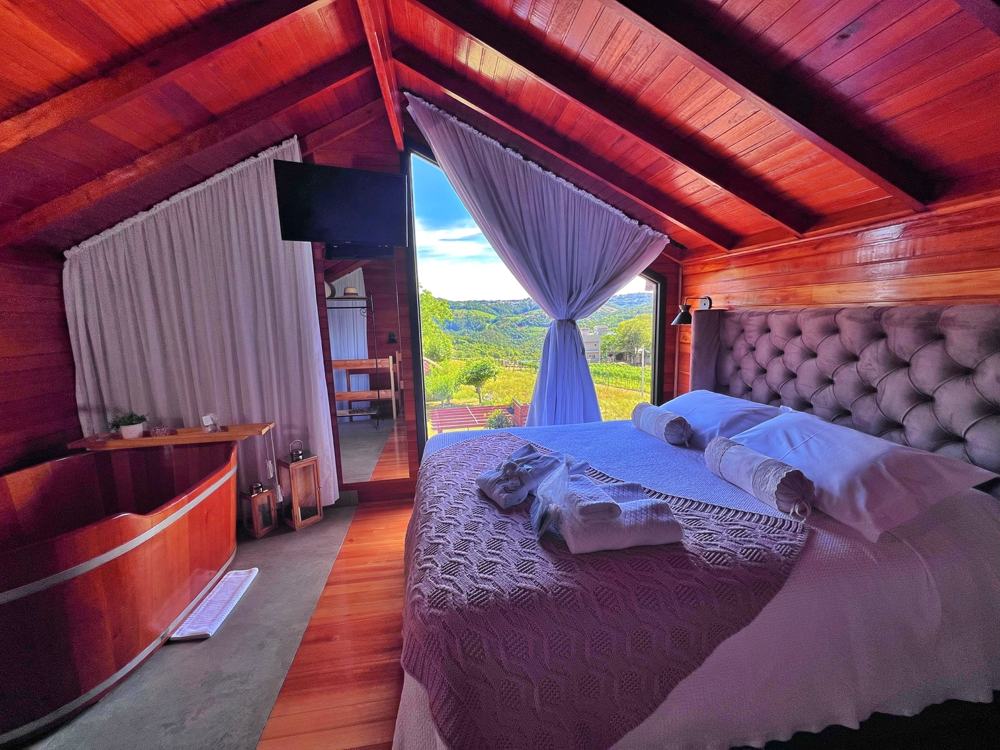 Quarto da Cabana Rosé com a cama, o ofurô e a janela pras montanhas