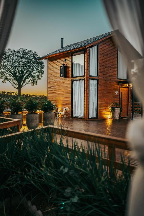 Uma das cabanas ao entardecer, com a árvore ao fundo