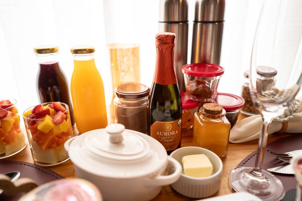 Sucos, frutas, manteiga e espumante do café da manhã