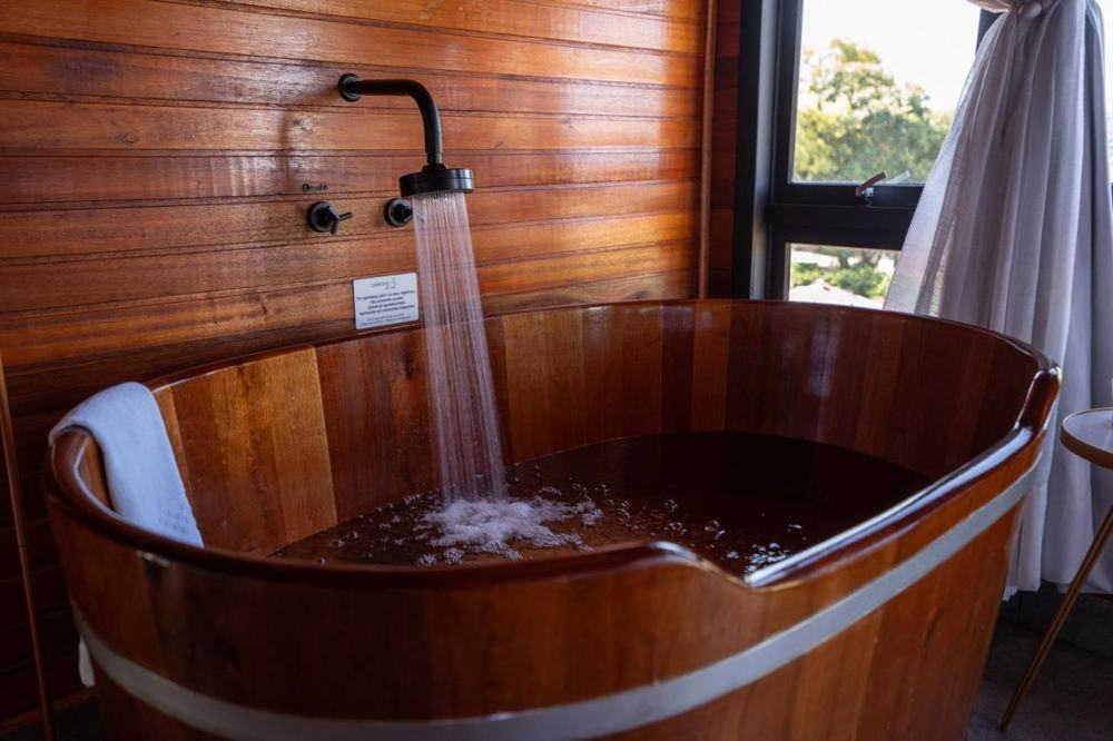 Ofurô de madeira enchendo de água quente
