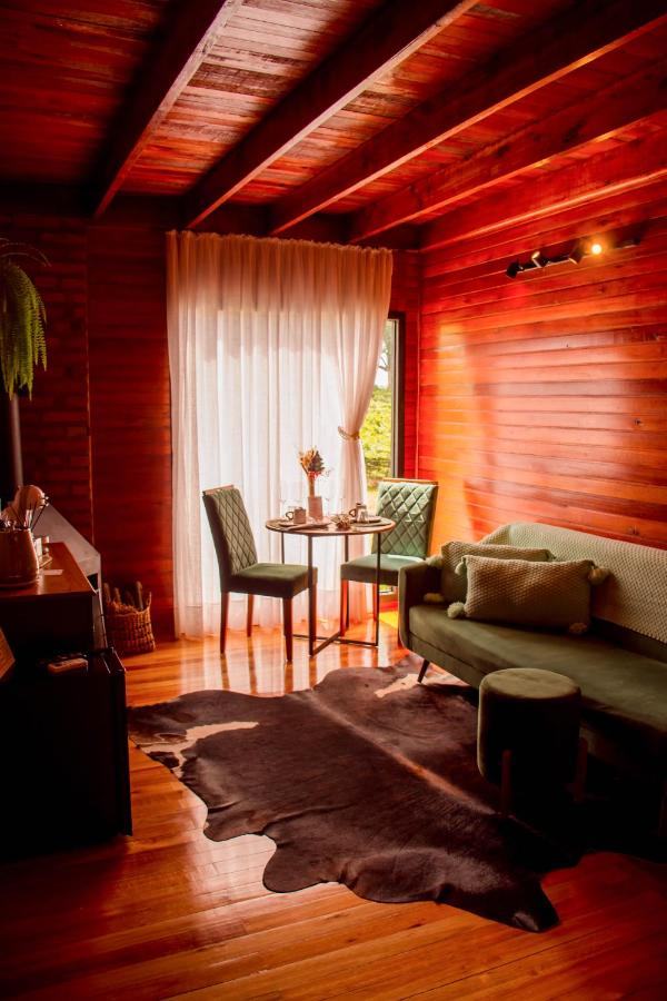 Sala da cabana com poltronas verdes e a mesinha